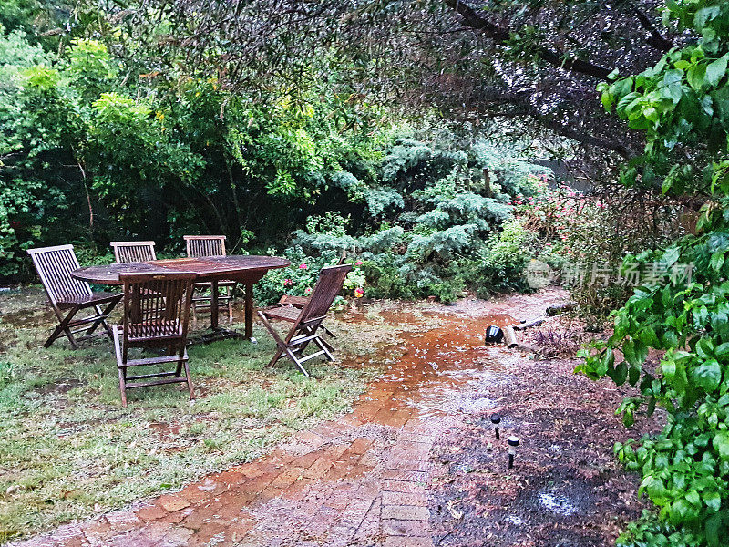 绿树成荫的花园，木制桌椅