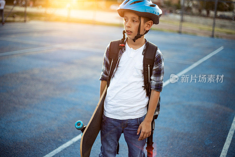 小学男孩在操场上玩滑板