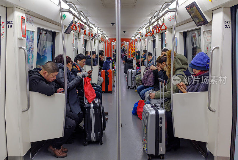 乘客拿着行李坐在地铁里看火车
