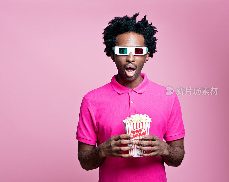 年轻男子戴着3d眼镜吃着爆米花的粉色肖像