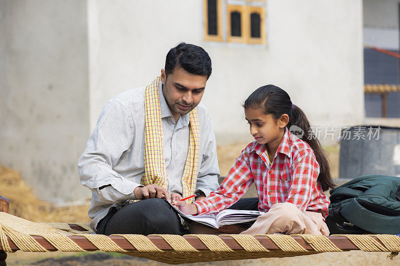 农村父亲帮助女儿与她的家庭作业库存照片