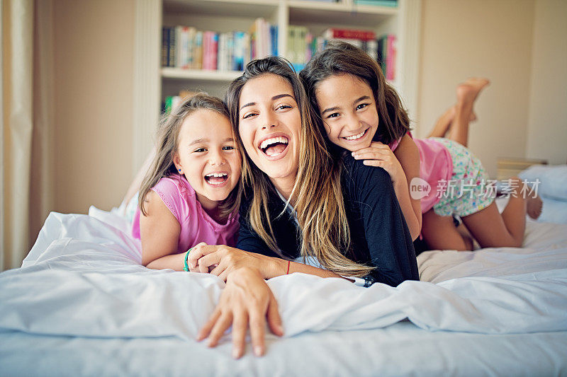 母亲和女儿们在床上的肖像