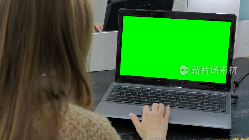 用绿屏笔记本电脑的女人