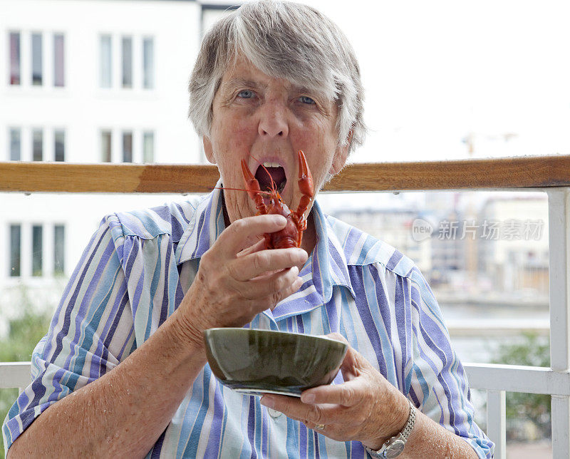 老妇人在吃水煮小龙虾。