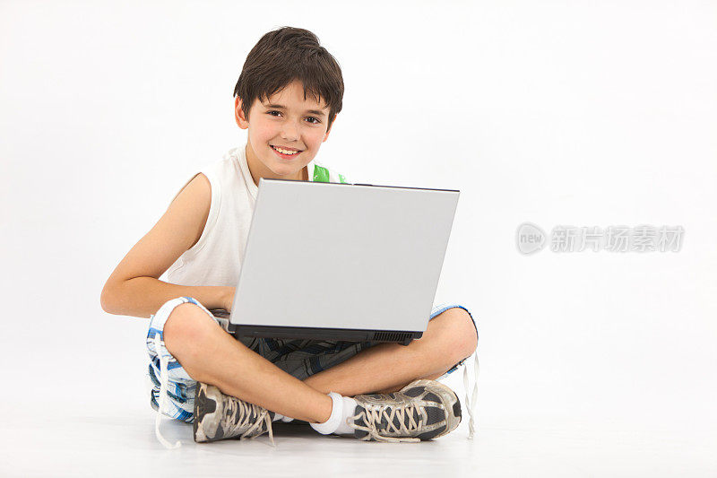 小学男孩用笔记本电脑在工作室拍摄