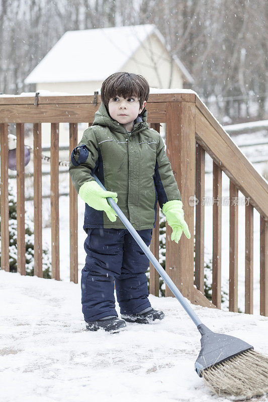 小男孩在清理桌子上的雪