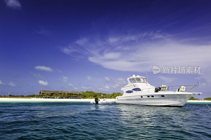 一艘豪华游艇停泊在热带岛屿的绿松石海滩上