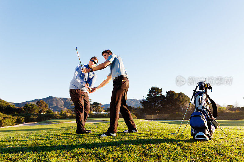高尔夫课:年轻教练帮助高尔夫球手在美丽的高尔夫球场