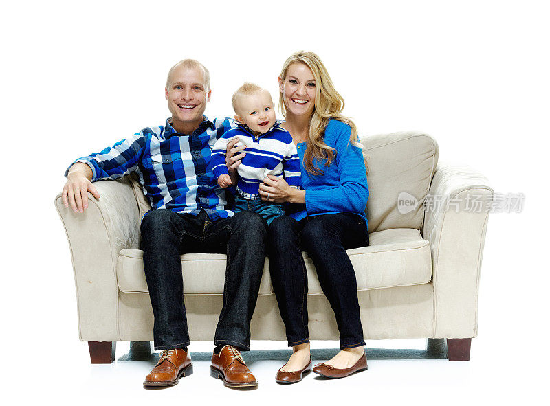 一对幸福的夫妇和他们的孩子坐在沙发上