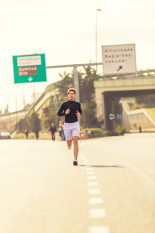 年轻的男运动员在马路上跑步