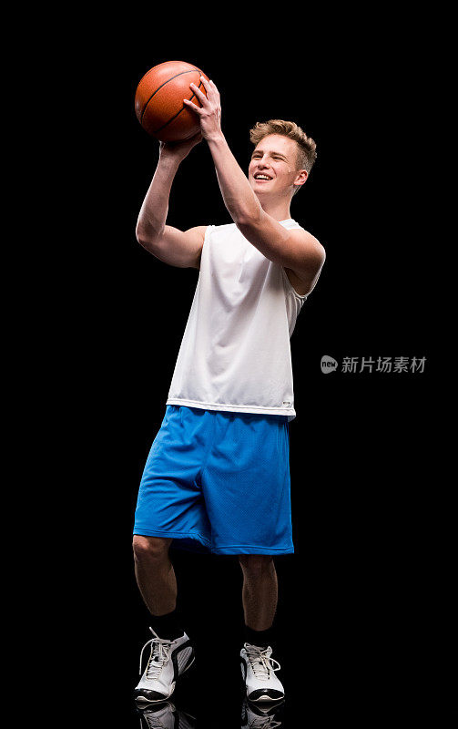 微笑的男运动员打篮球