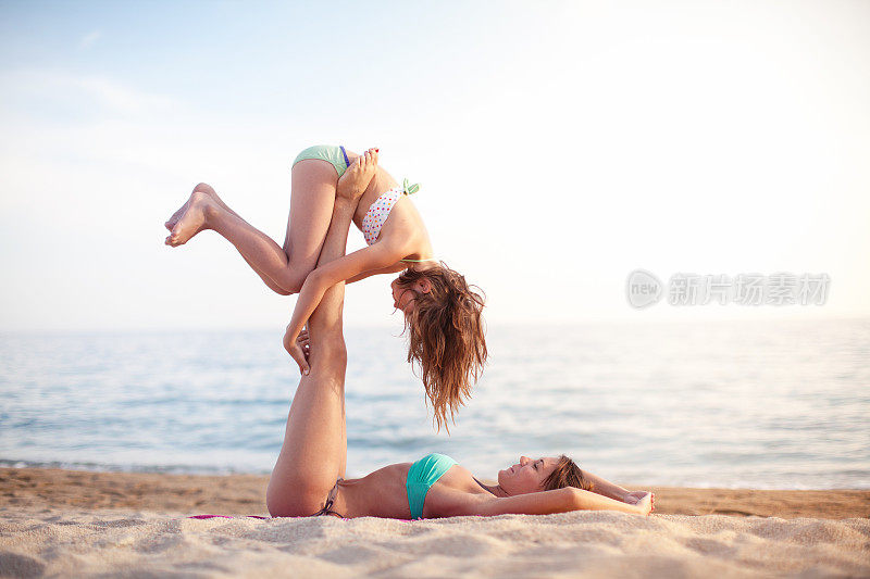 母亲和女儿在海滩上锻炼