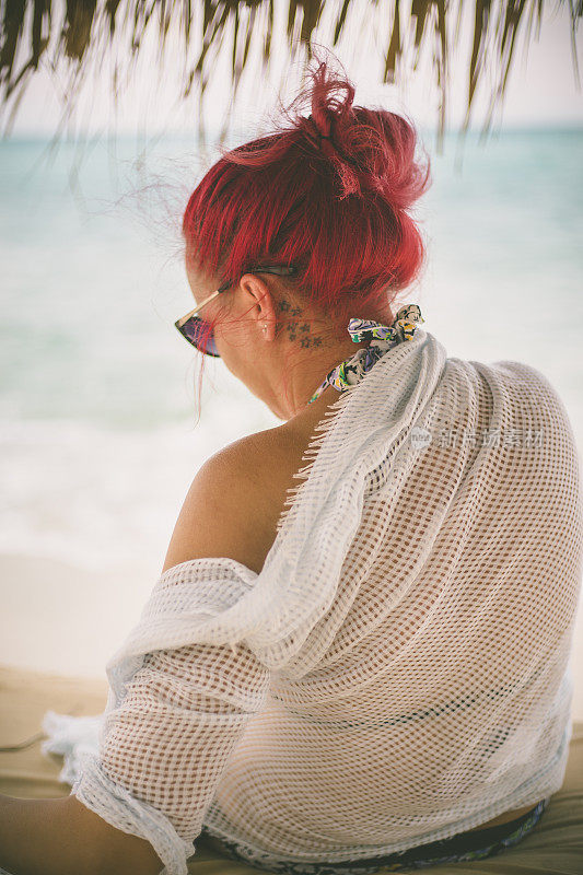 穿着夏装的女人望着天空和大海