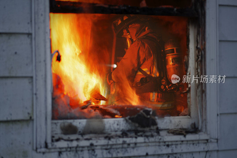 消防队员在燃烧的房屋中行动。