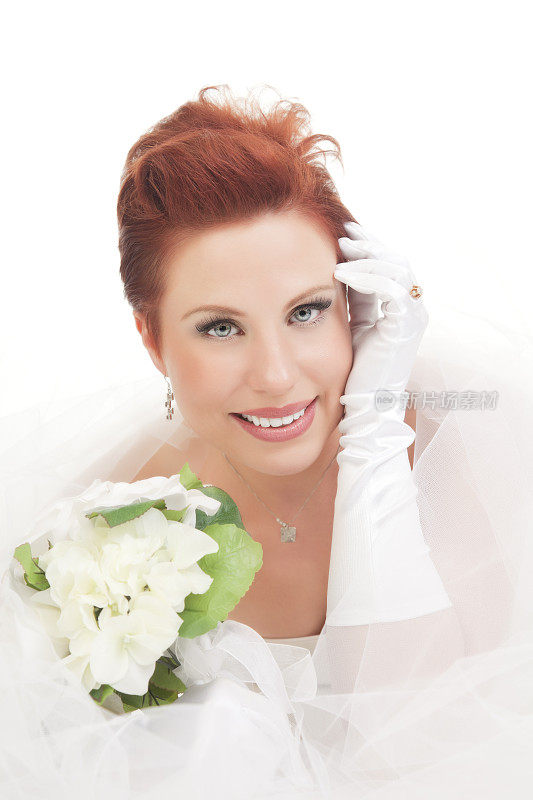 一个美丽的新娘的肖像与白色的鲜花和面纱