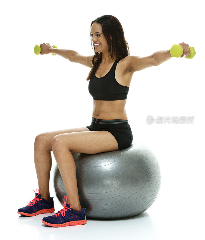 穿着运动服的女人坐在健身球上