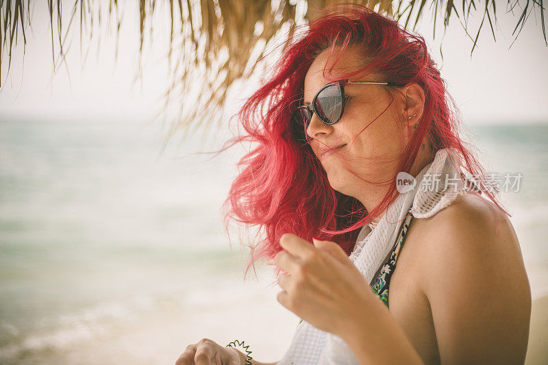 穿着夏装的女人望着天空和大海