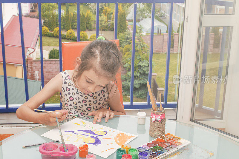 女孩在纸上和手上画颜料