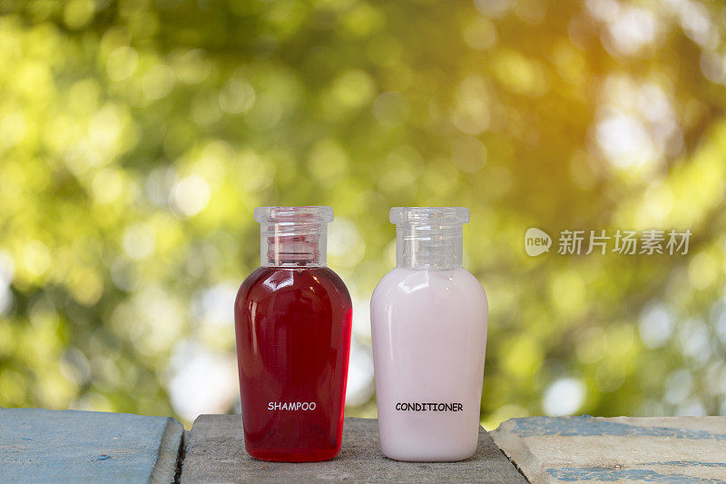 小瓶的洗发水和护发素与抽象的自然背景。