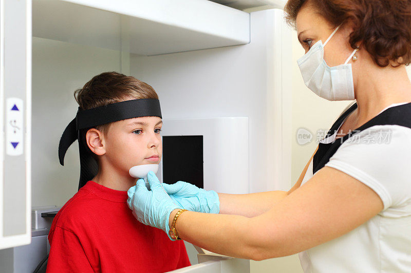 牙医在面具准备男孩颌骨x光成像