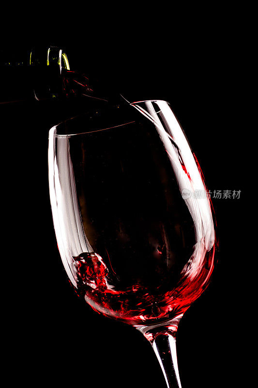 在黑色背景下，红酒从酒瓶中倒入酒杯。酒单设计菜单与拷贝空间。