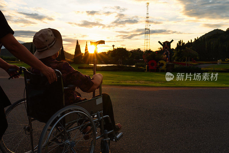 妇女们推着轮椅上的老妇人。