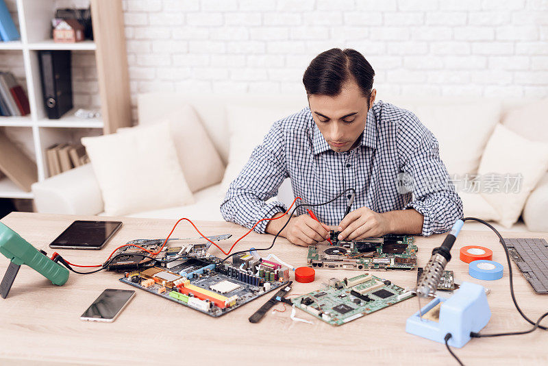 这个人是无线电技术员。一个男人正在修理印刷电路板。