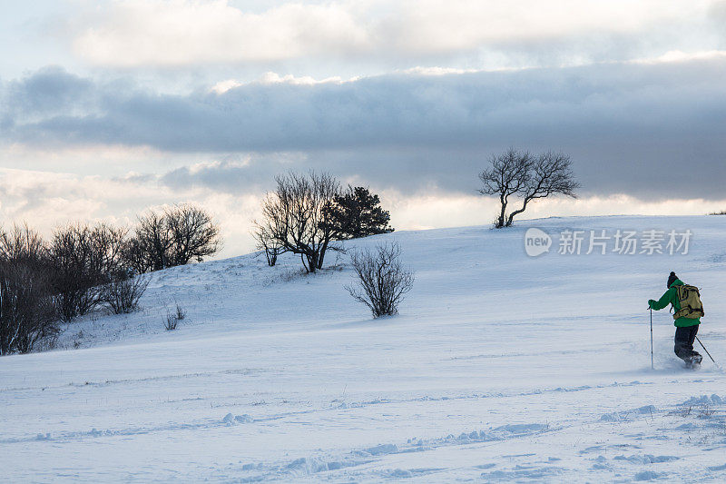 用登山杖在雪景上奔跑的徒步者