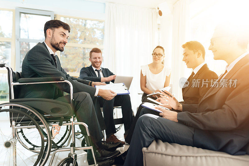 残疾人会议在一个明亮的房间和宽阔的窗户。坐轮椅的男人，商人。