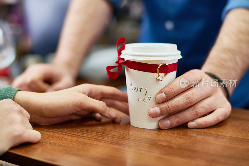 男人送咖啡杯和订婚戒指