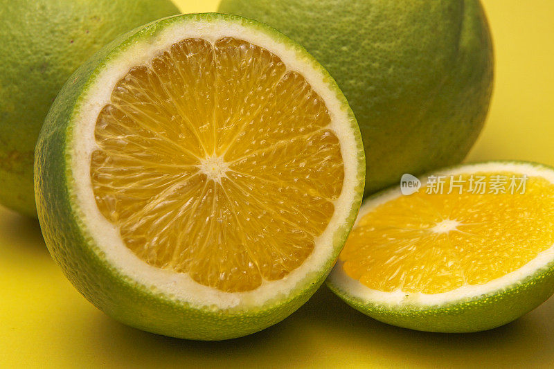 绿色的橘子橙色切片在黄色的背景