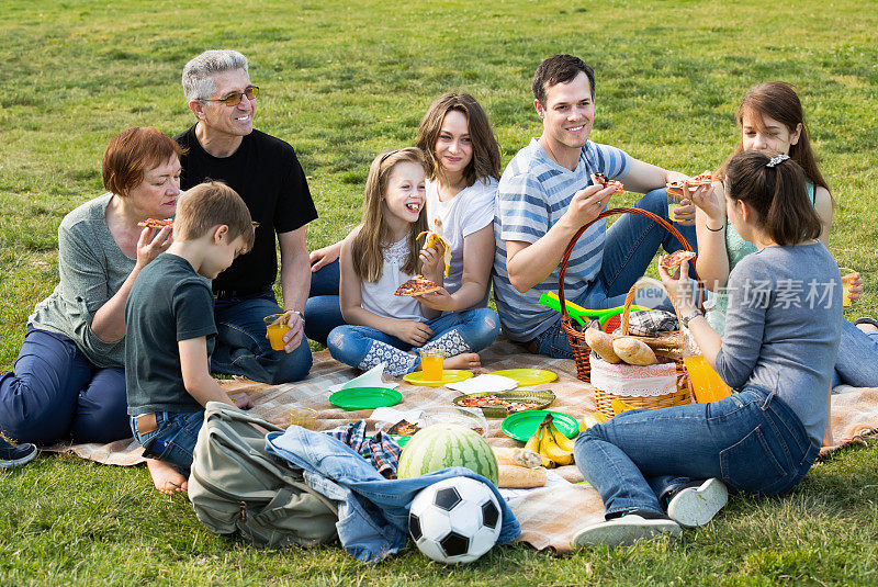 一家人和孩子们在公园野餐吃披萨