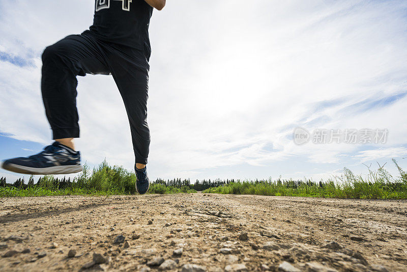 跑步者迎着乌云在土路上奔跑