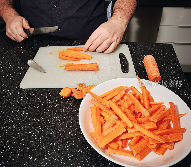 厨师用切割机切新鲜的胡萝卜