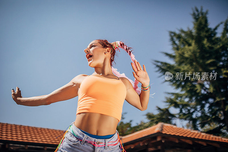 一位年轻的现代女舞者在一个阳光明媚的夏日在户外跳舞