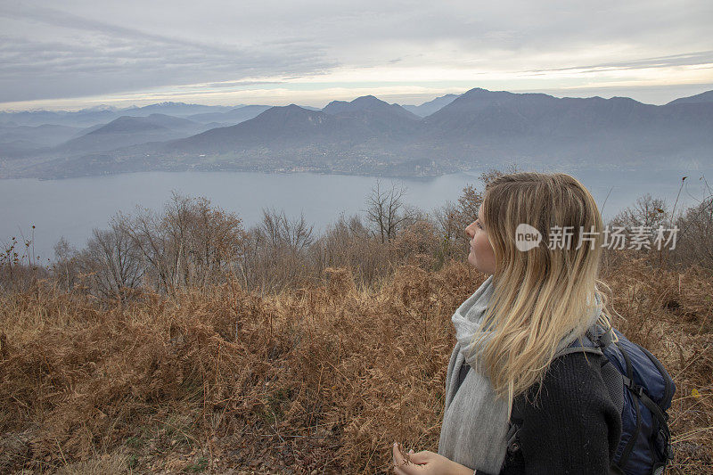 年轻女子望着草地，望着湖泊和山脉