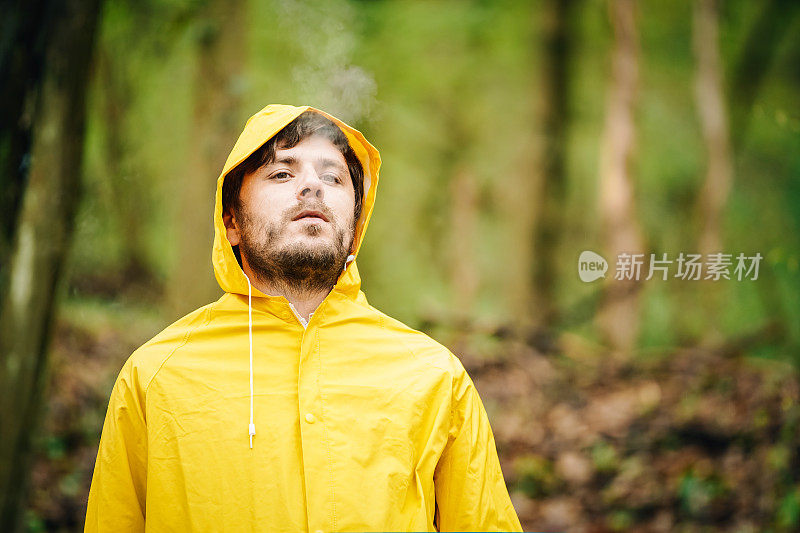 穿雨衣和抽烟的男人的肖像