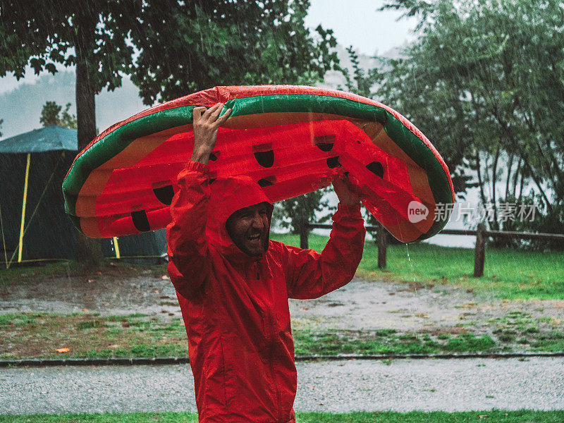 一名男子在露营时被困在暴风雨中，用充气木筏盖住