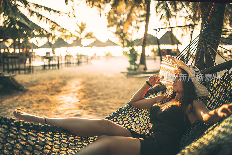 情侣们在海滩上放松，在热带岛屿上享受美丽的大海