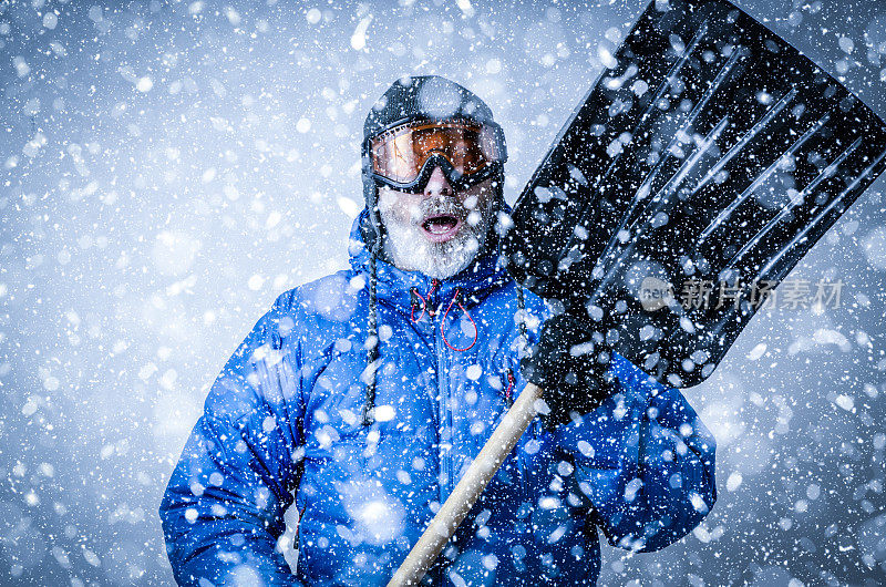 在暴风雪中戴着护目镜和铲子的人