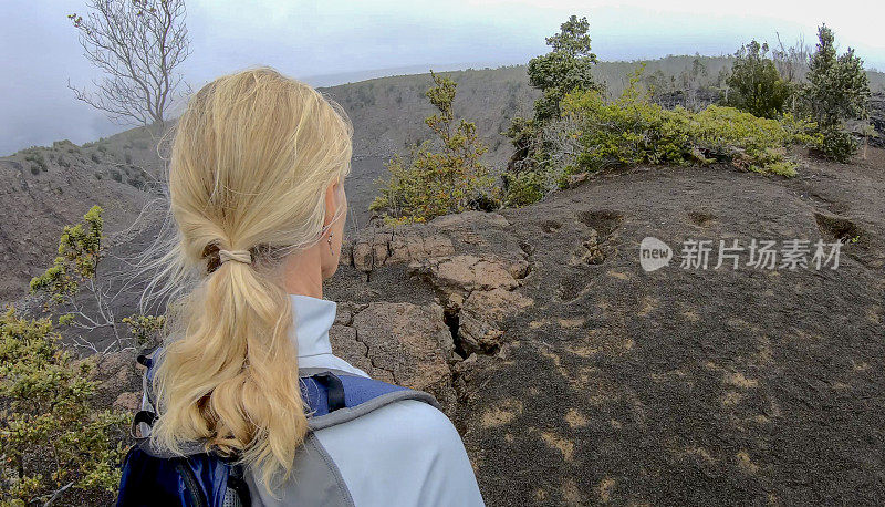 女人沿着火山边缘徒步旅行