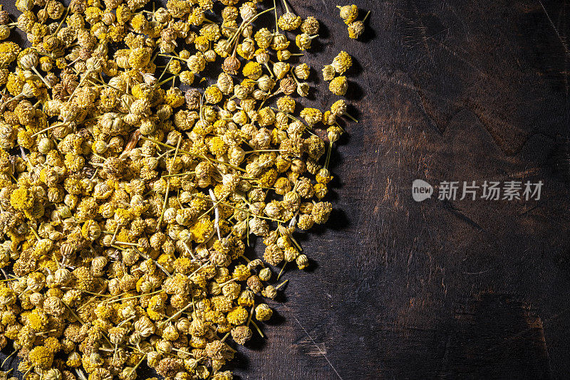 洋甘菊干花茶在黑暗的木材背景