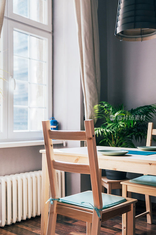 现代室内设计的厨房空间用小桌子，用简单的椅子和植物装饰