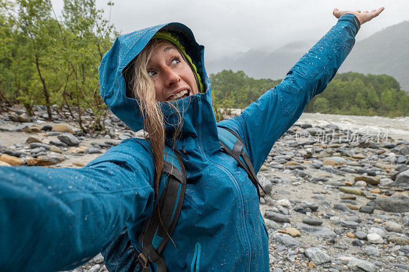 女徒步旅行者在雨中自拍