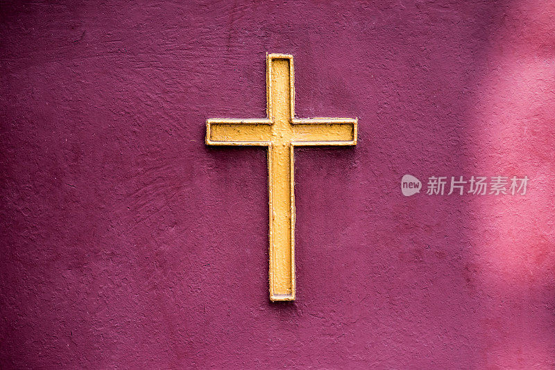 金色耶稣十字架象征在红紫罗兰墙上