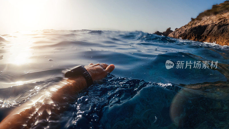 一个男人在夏天的海里游泳和浮潜