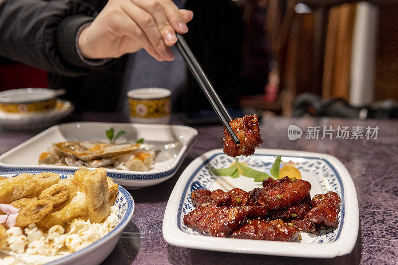 男人在餐厅吃糖醋排骨