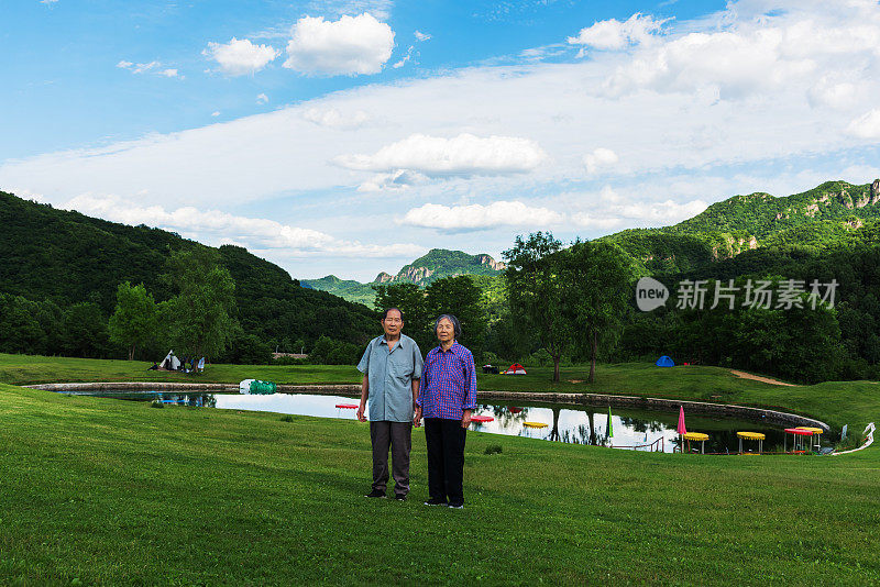 在北京的一个自然公园里，两位中国老人手牵着手欣赏风景