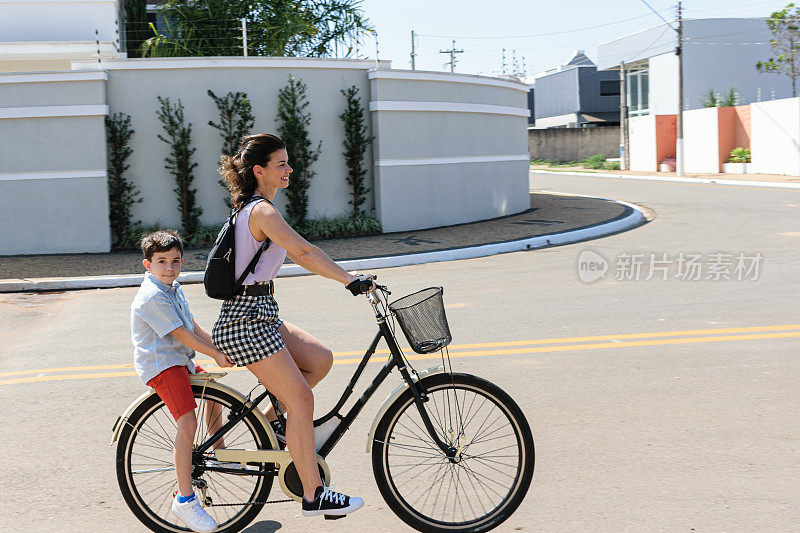巴西母亲和儿子在一个阳光明媚的早晨骑着自行车。