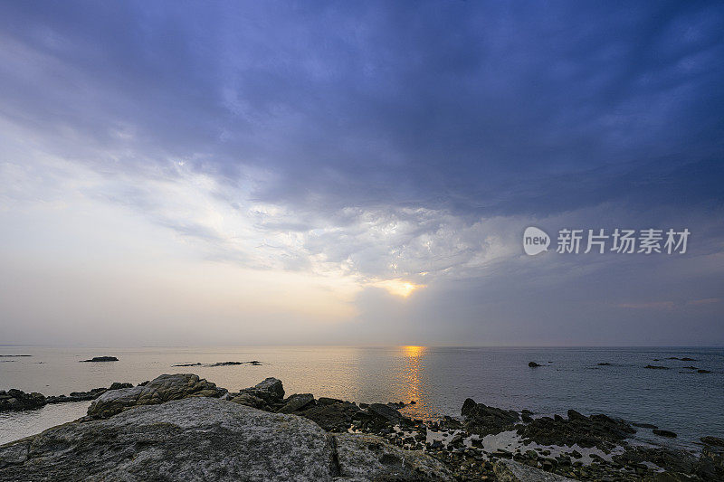 山东清晨沙滩上的岩石和多变的云朵